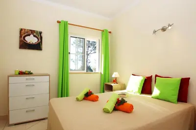 a bedroom with two twin beds with green curtains at Villa Bella Vista by Algarve Vacation in Albufeira