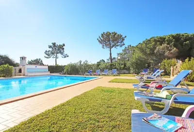 a row of lounge chairs next to a swimming pool at Villa Bella Vista by Algarve Vacation in Albufeira
