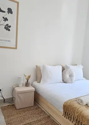 a bed with white sheets and pillows in a room at City Center Villa in Faro