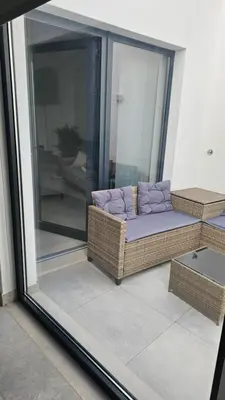 a balcony with a couch and a glass door at City Center Villa in Faro