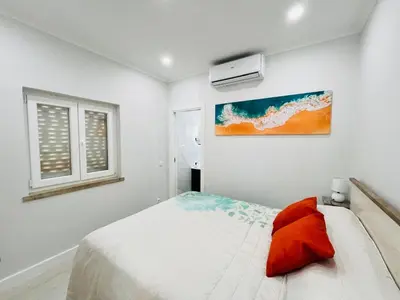 a white bedroom with a bed and a painting on the wall at BrisaMarVilas Sea view, 5 min Walk to Town & Beach in Albufeira