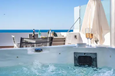 a tub filled with water with a glass of wine at Apartment Atlantic - Vale de Lobo in Almancil