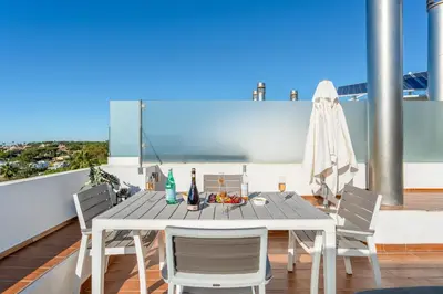 a dining table and chairs on a balcony with a view at Apartment Atlantic - Vale de Lobo in Almancil