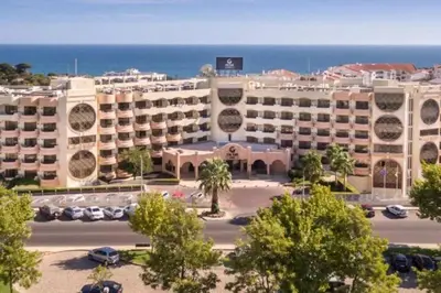 a large building with a parking lot in front of the ocean at Self-Catering Studios & Apartments at Hotel Cerro Alagoa in Albufeira