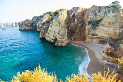 a view of a beach with rocks and the ocean at Appartement Quarteira in Quarteira