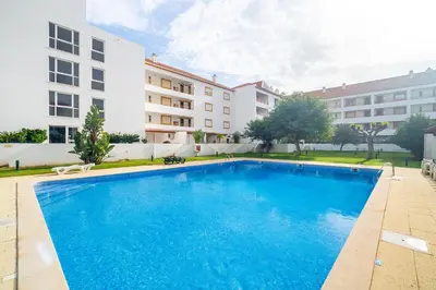 a large blue swimming pool in front of a building at Vilamoura Family Escape in Quarteira