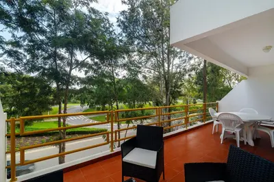 a balcony with a table and chairs and trees at Vilamoura Family Escape in Quarteira