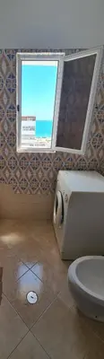 a bathroom with a window and a toilet at Quarteira Azul in Quarteira