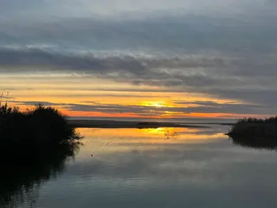 a sunset over a river with the sun setting at Casa Algarve in Albufeira