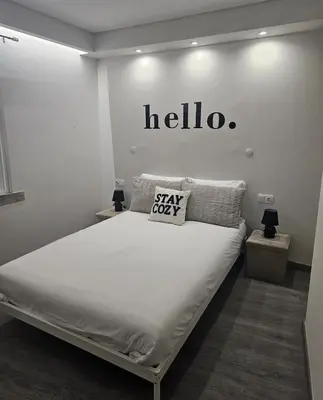 a bedroom with a bed with a hello sign on the wall at Oldtown Nightlife in Faro