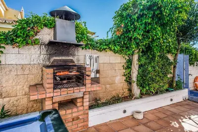 a brick wall with an outdoor grill in a yard at Atlantic Sul in Albufeira