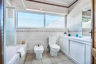 a bathroom with a toilet and a sink and a window at Atlantic Sul in Albufeira