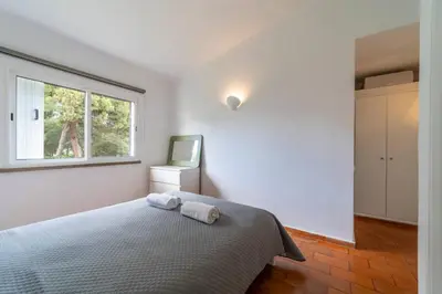 a white bedroom with a bed and a window at Villa Uno by HelloVacations in Loulé