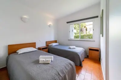 a bedroom with two beds and a window at Villa Uno by HelloVacations in Loulé
