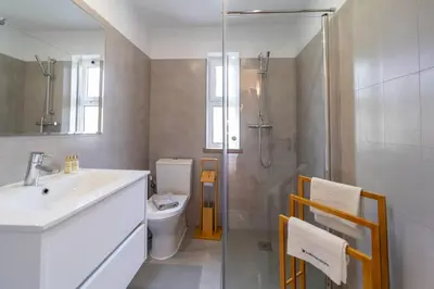 a bathroom with a toilet and a sink and a shower at Villa Uno by HelloVacations in Loulé