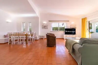 a living room with a table and a dining room at Villa Uno by HelloVacations in Loulé