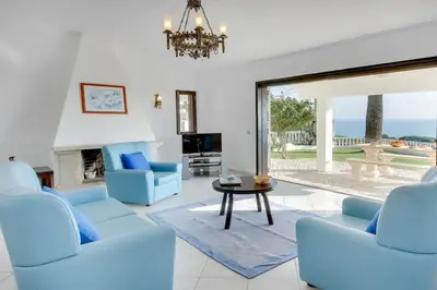 a living room with blue chairs and a table at Casa Sol in Albufeira