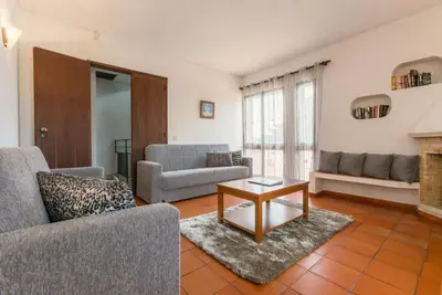 a patio with a table and chairs and an umbrella at Villa Praia in Albufeira