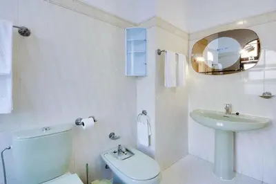 a white bathroom with a toilet and a sink at Villa Mar in Albufeira