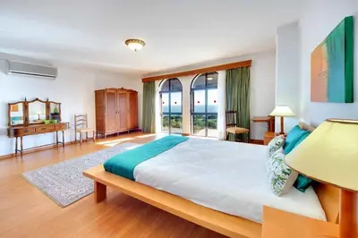 a bedroom with a large bed and a large window at Villa Mar in Albufeira