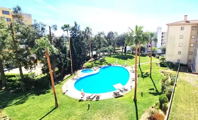 an overhead view of a swimming pool in a park with palm trees at T2 Vilamoura - com piscina e campo tenis in Vilamoura