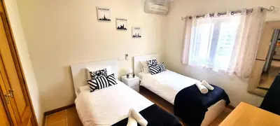 a room with two beds and a window at T2 Vilamoura - com piscina e campo tenis in Vilamoura