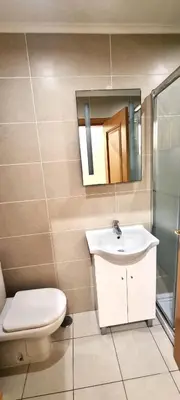 a bathroom with a toilet and a sink and a mirror at T2 Vilamoura - com piscina e campo tenis in Vilamoura