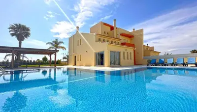 a large swimming pool in front of a building at Stunning Villa with Heated Pool, Garden, BBQ in Quarteira