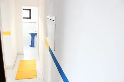 a bathroom with a yellow rug on a wall at Rich & Poor Hostel Albufeira in Albufeira