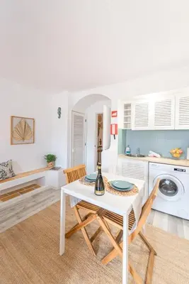a kitchen with a white table and chairs and a washing machine at Albufeira Central Studio w swim pool and Seaview in Albufeira
