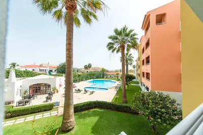a view of a resort with a swimming pool and palm trees at Albufeira Central Studio w swim pool and Seaview in Albufeira