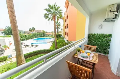 a balcony with a table and chairs and a view of a pool at Albufeira Central Studio w swim pool and Seaview in Albufeira