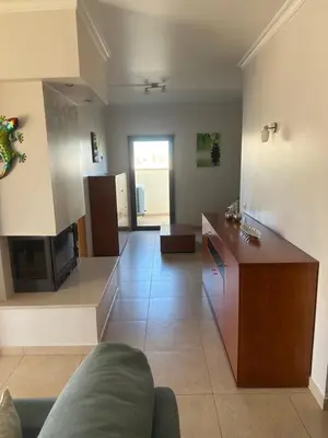 a large living room with a couch and a kitchen at Jardins da guia in Albufeira