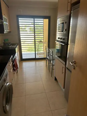 a kitchen with a large tile floor and appliances at Jardins da guia in Albufeira