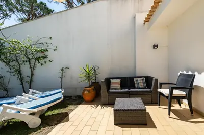 a patio with a couch and a table and chairs at Vilamouratenis Sunscape by SAPvillas in Vilamoura