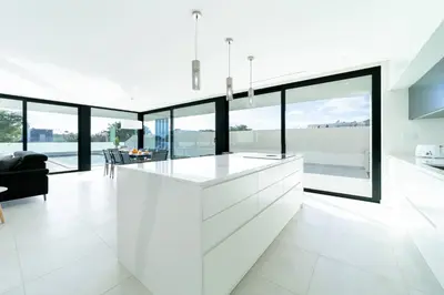 a white kitchen with large windows and a kitchen island at Villa Marina - 33 by HelloVacations in Albufeira