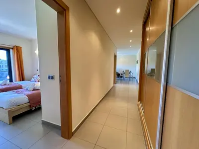 a hallway of a bedroom with a bed and a mirror at Quarteira Stylish 3 with Pool by Homing in Quarteira