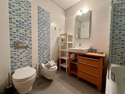 a bathroom with a toilet and a sink and a mirror at Quarteira Stylish 3 with Pool by Homing in Quarteira