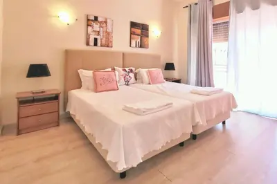 a bedroom with a large bed with pink pillows at Villa Atlantico in Quarteira