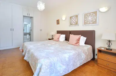 a bedroom with a large bed with pink pillows at Villa Atlantico in Quarteira