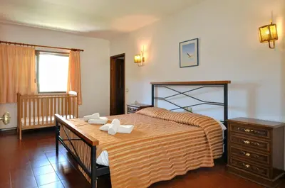 a bedroom with a bed and a table with towels on it at Villa Gardenia in Quarteira