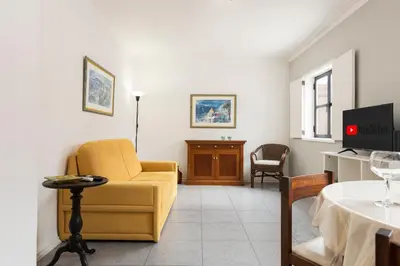 a living room with a yellow couch and a tv at LUIS - Vilamoura in Vilamoura
