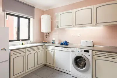 a kitchen with a washing machine and a sink at LUIS - Vilamoura in Vilamoura