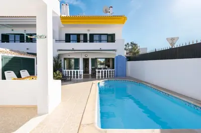 a villa with a swimming pool in front of a house at #039 Family Private Pool AC in Albufeira