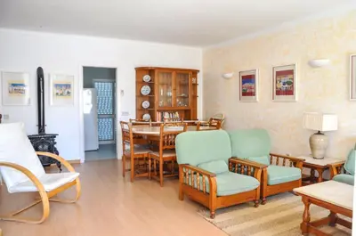 a living room with a dining room table and chairs at Vista Golfe in Quarteira