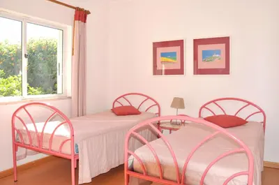 two beds in a room with two windows at Vista Golfe in Quarteira