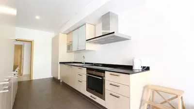 a kitchen with white cabinets and a stove top oven at Aquamar 15 - Clever Details in Vilamoura