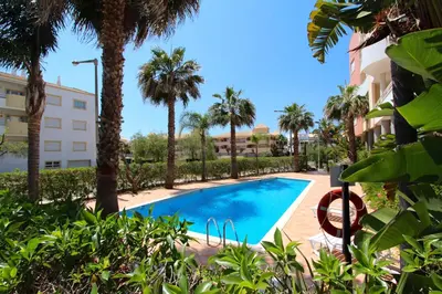 a swimming pool in front of a building with palm trees at Antelius 82 - Clever Details in Vilamoura