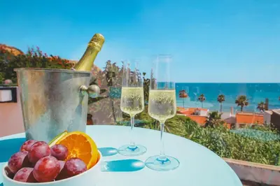 a table with two glasses of wine and a bowl of fruit at Casa do Cacto in Olhos de Água