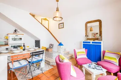 a living room with pink chairs and a desk at Casa do Cacto in Olhos de Água